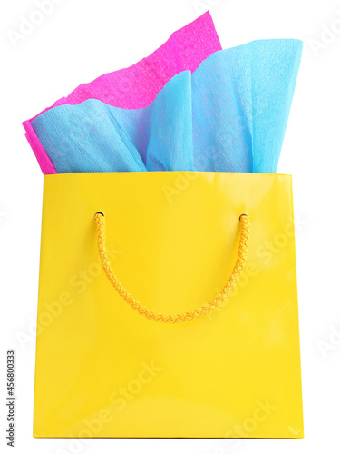 Yellow gift bag stuffed with pink and turquoise tissue paper, isolated on white