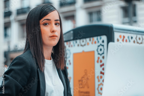 Mujer de negocios con indignación y melancolía realizando su trabajo en una plaza del pueblo junto con su computadora escribiendo sus últimos trabajos 