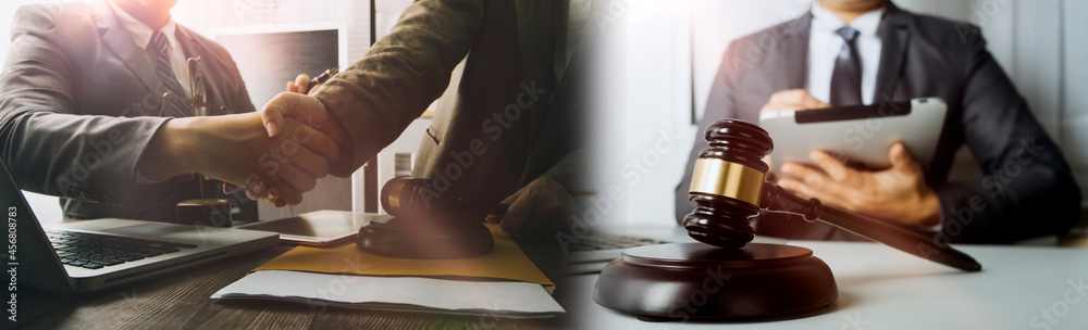 Obraz premium Justice and law concept.Male judge in a courtroom with the gavel, working with, computer and docking keyboard, eyeglasses, on table in morning light