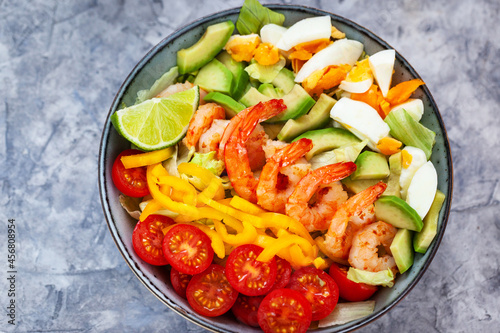 Delicious fresh salad with prawns, avocado, eggs, bell pepper, tomatoes and herbs
