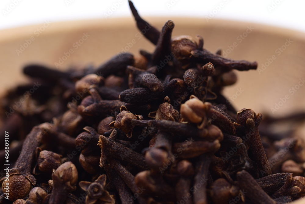 Cloves in a wooden bowl on a white background. Spices. Food. Cloves in a wooden bowl on a white background. Spices. Food.