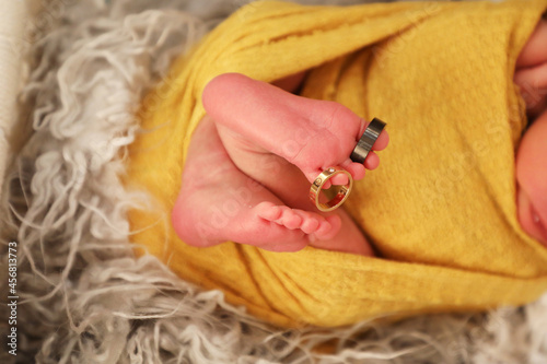 closeup of newborn baby boy feet with rings in toe and finger,peaceful health concept photo