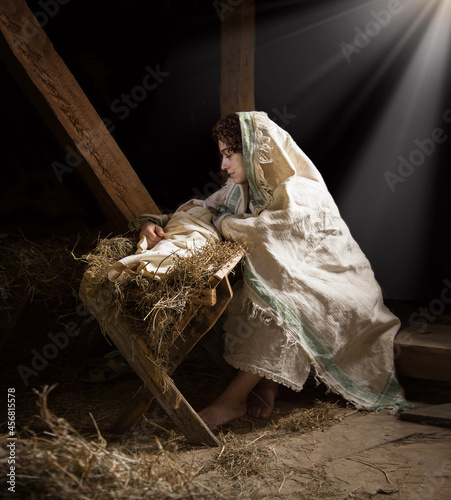 Valokuva Mary sits in the stable near the manger with the baby