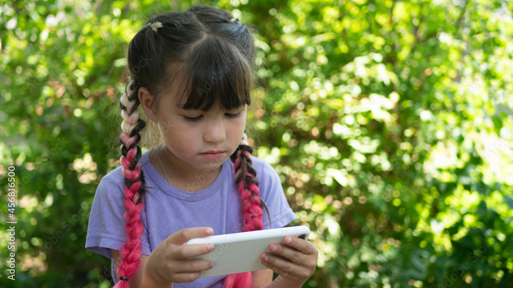 Little beautiful girl with pink hair using the phone outdoors. Kids and Technology, smartphone, e-learning
Little beautiful girl with pink hair using the phone outdoors. Kids and Technology, smartphone, e-learning