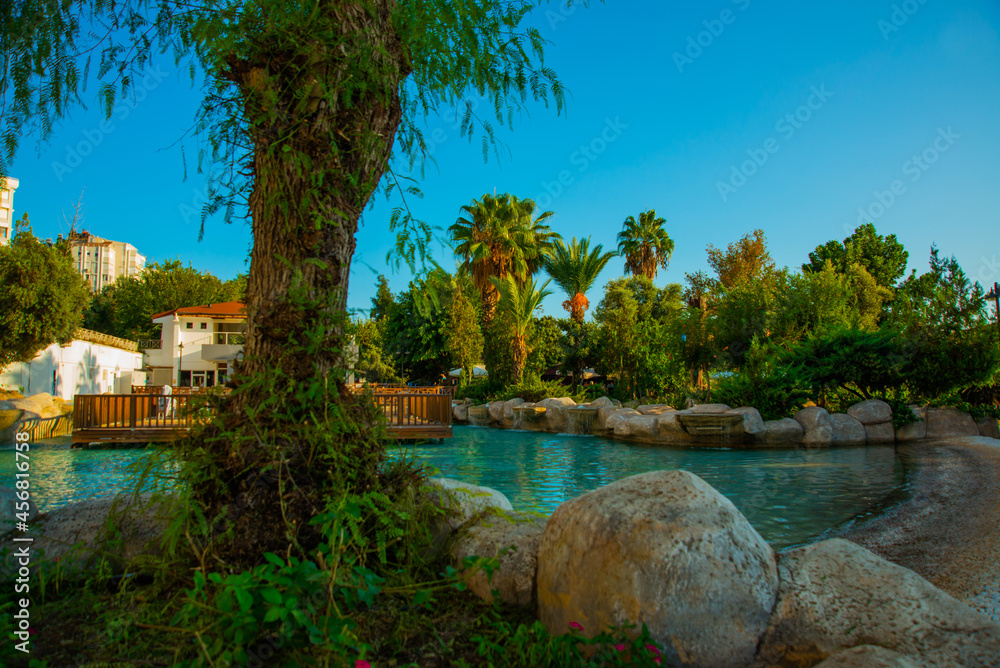 ANTALYA, TURKEY: Landscape with a view of a beautiful park with a fountain and a pond in Antalya on a sunny summer day. ANTALYA, TURKEY: Landscape with a view of a beautiful park with a fountain and a pond in Antalya on a sunny summer day.