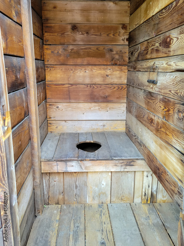A rustic, historic wooden toilet in an outhouse in the American west. photo