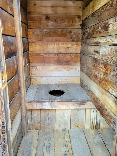 Photography A rustic, historic wooden toilet in an outhouse in the American west