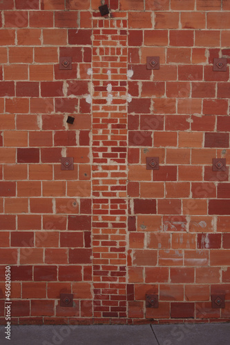 Partial view of a red brick building wall retrofitted against earthquakes