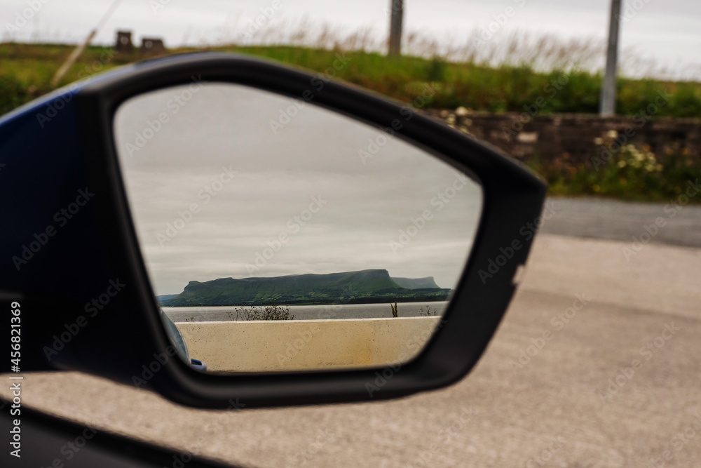 Benbulben flat top mountain reflection in a car mirror. Travel concept. County Sligo, Ireland. Popular landmark.