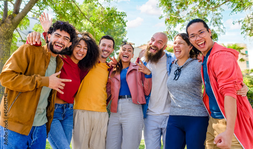 portrait of multiethnic group of friends posing in the street outdoors laughing and having fun. diverse people celebrating life together enjoying happy holidays. lifestyle, travel and joy concept