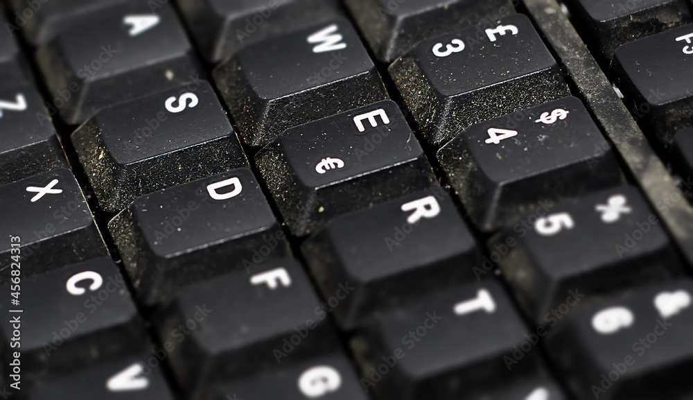 Detail of the buttons of a dusty black plastic european computer keyboard. Detail of the buttons of a dusty black plastic european computer keyboard.