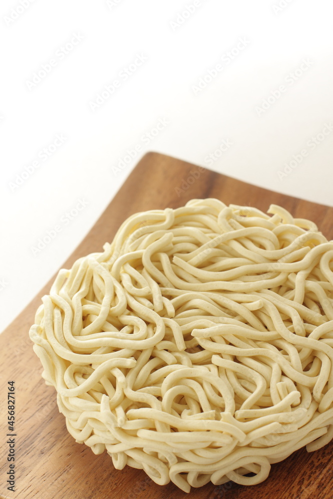 Dried round shaped instant noodles on wooden plate