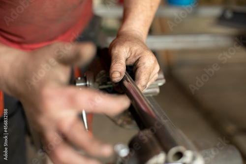 The man fixes the part in a vice. Hand and metal.