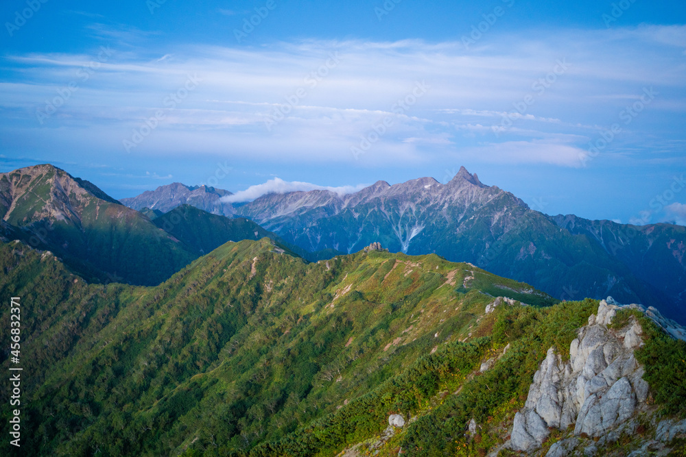 Fototapeta premium 燕岳頂上付近の山荘から見る朝日が当たる槍ヶ岳の風景 A view of Mt. Yarigatake in the morning sun from the mountain lodge near the top of Mt. Tsubakuro.