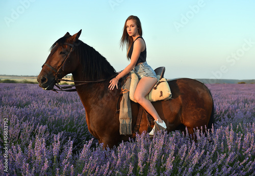 a blonde model riding a horse in a lavender field