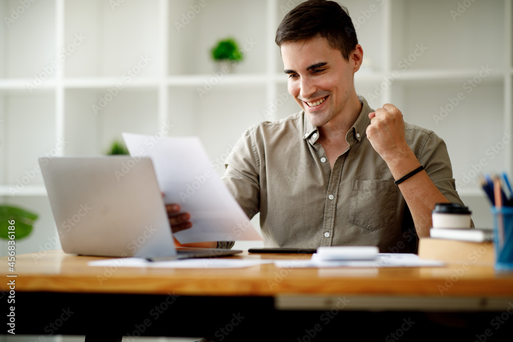 Portrait of Happy excited successful young businessman or handsome man triumphing in office,businessman working on laptop computer. Portrait of Happy excited successful young businessman or handsome man triumphing in office,businessman working on laptop computer.