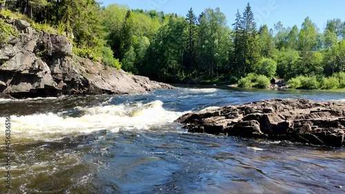 A large amount of water flowing in the Numedalslagen river in Norway on a sunny day. photo