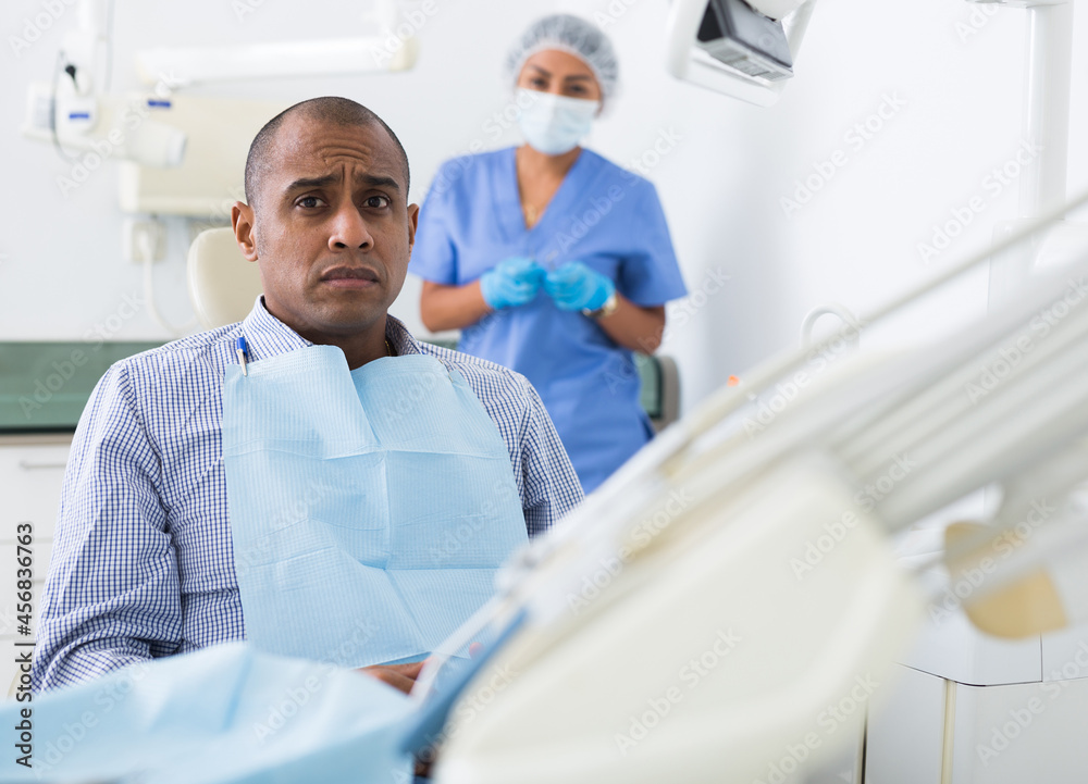 Fototapeta premium Patient is afraid to have his teeth treated at the dentist