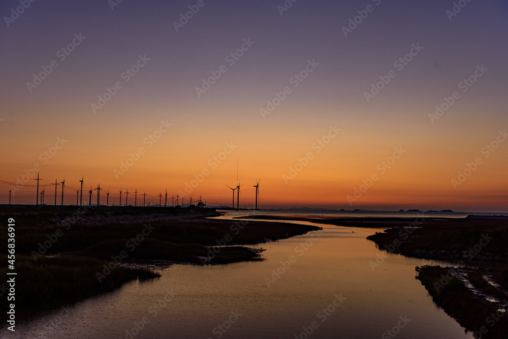 wind turbines sunset over the sea