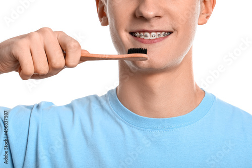 Принти на полотні Handsome man with dental braces and toothbrush on white background, closeup