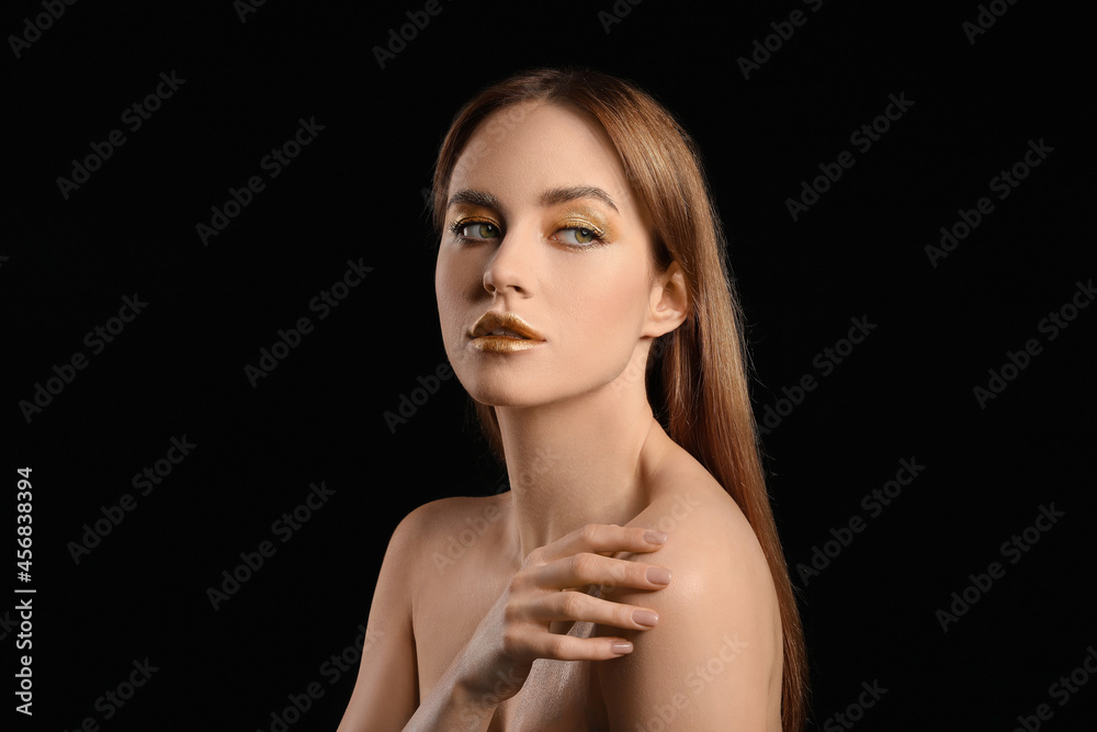 Beautiful young woman with golden makeup on black background Beautiful young woman with golden makeup on black background