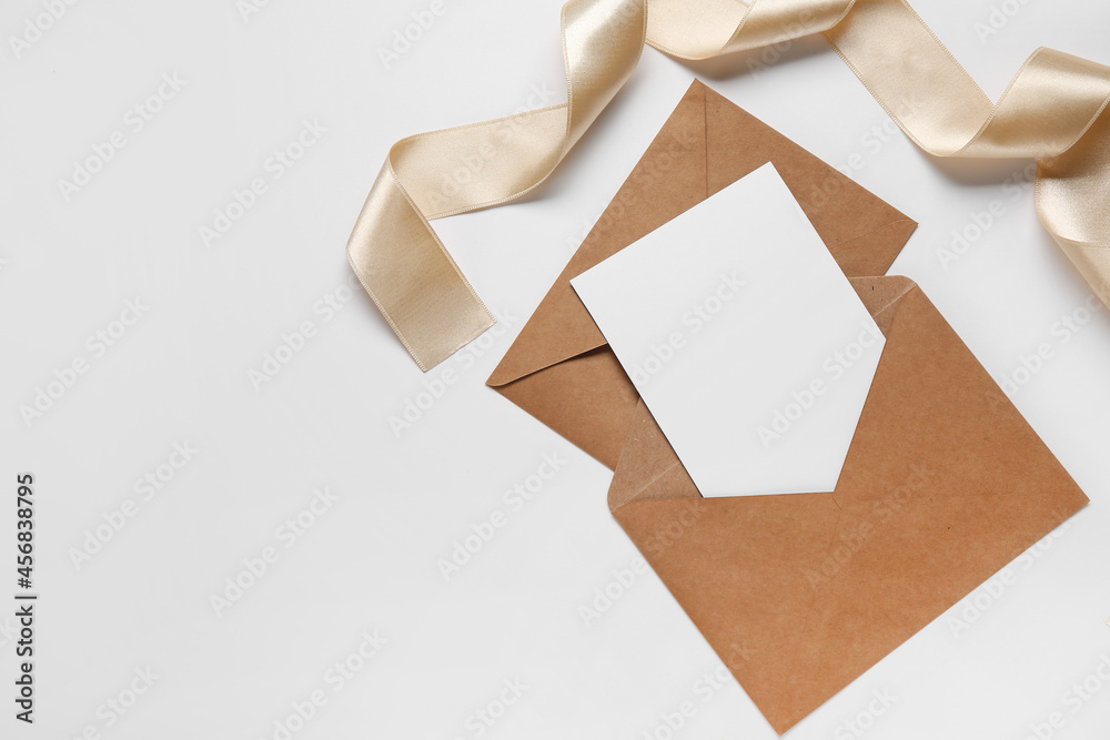 Envelopes with blank card and ribbon on white background Envelopes with blank card and ribbon on white background