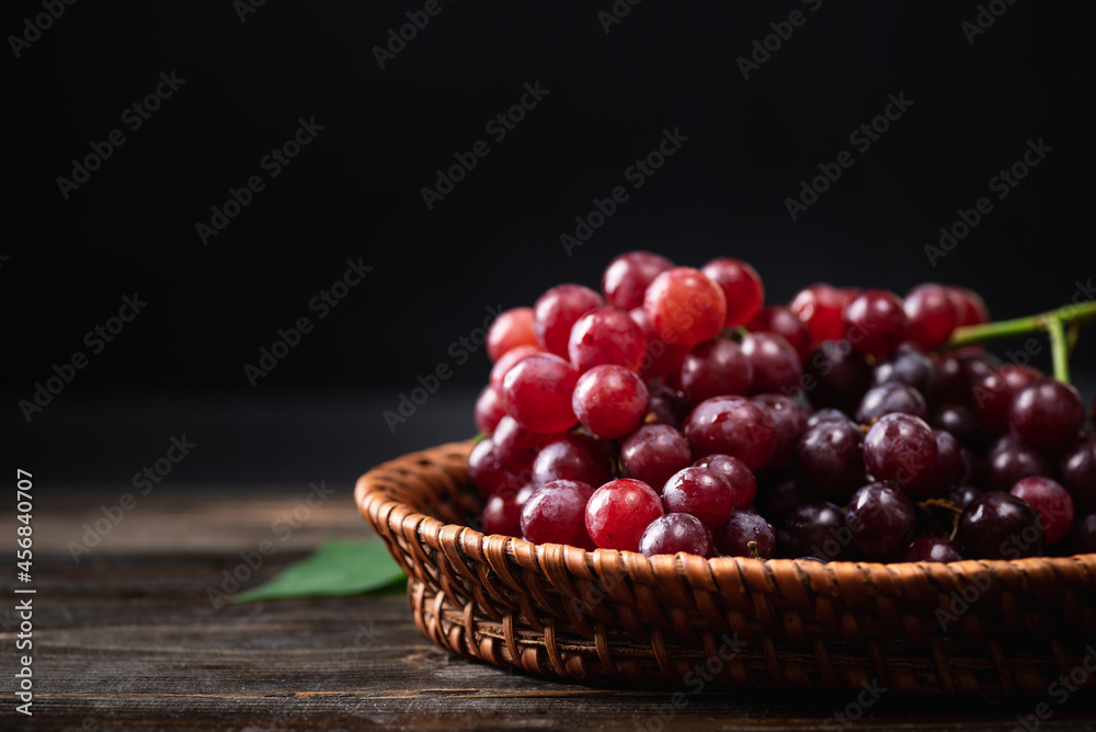 Fresh red grape in a basket on wooden with black background, Organic tropical fruit, Still Life Fresh red grape in a basket on wooden with black background, Organic tropical fruit, Still Life
