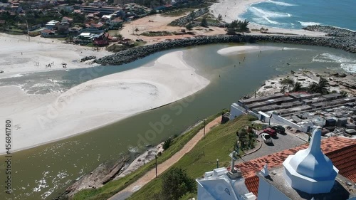 Aerial view of Saquarema and Itaúna beach in Rio de Janeiro. Famous for the waves and the church on top of the hill. Sunny day. Drone take.	
