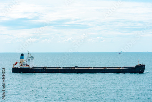 Bulk carrier ship  sailing through calm  blue sea.