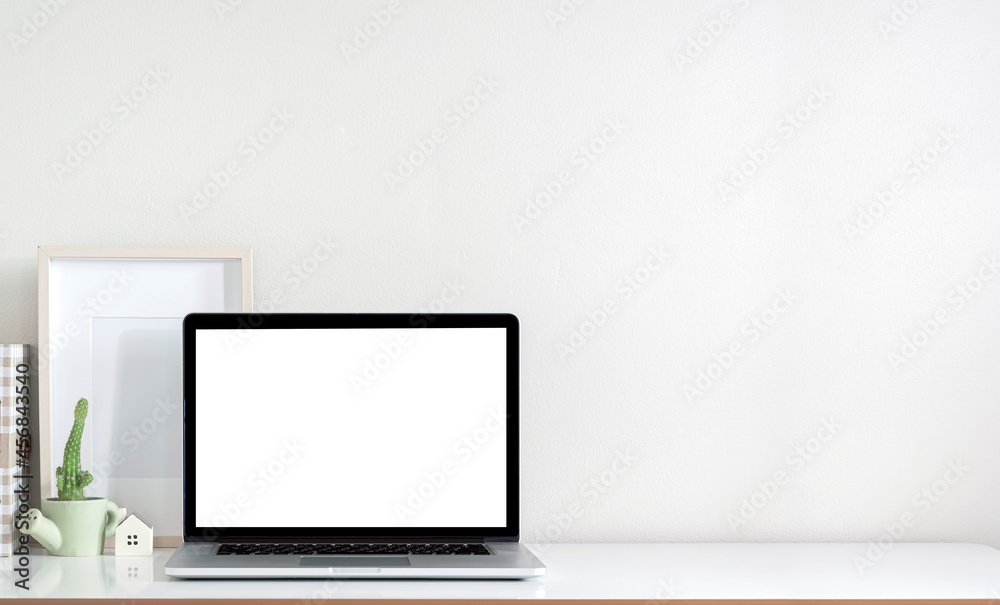 Mockup blank screen laptop computer, wooden frame and plant on white top table with copy space. Mockup blank screen laptop computer, wooden frame and plant on white top table with copy space.