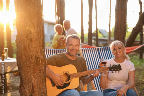 Mature man playing guitar a...