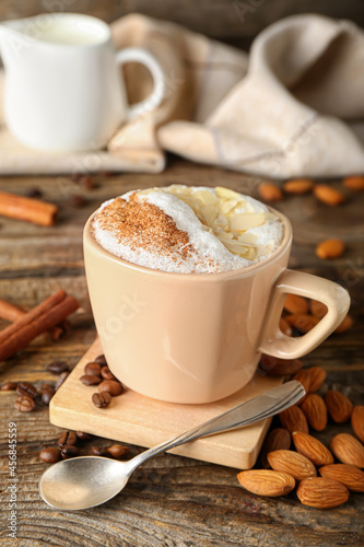 Fototapeta Naklejka Na Ścianę i Meble -  Cup of tasty almond latte with cinnamon on wooden background