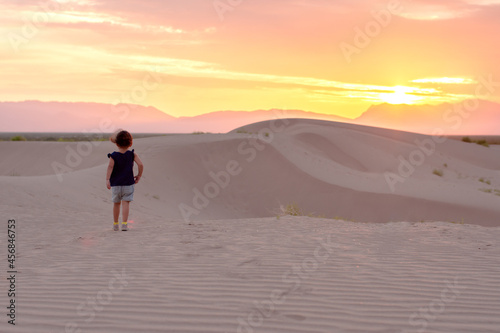 Unrecognizable child walking in a desert at sunrise © ERNESTO