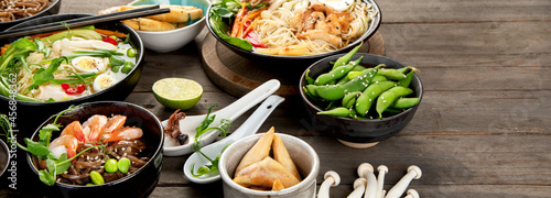 Asian dishes and snacks on wooden background.