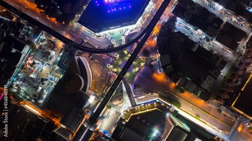 Time lapse of aerial view of Siam Bangkok Art and Skywalk aerial view in MBK Culture Center intersection or junction with cars traffic skyscraper buildings. Bangkok City in downtown at night, Thailand