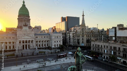 Pedestal shot of two congresses monument in the foreground at congressional plaza with Palace of the Argentine National Congress and Confiteria del Molino in the background, Buenos Aires at sunset. photo