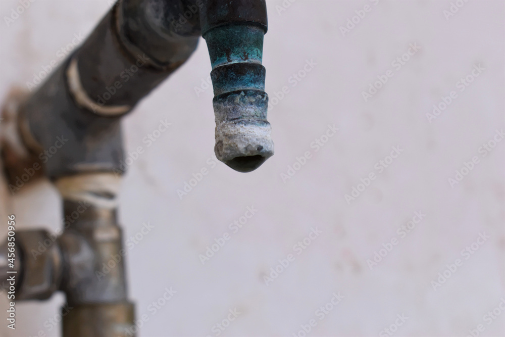 A faucet with a water drop closeup , Water consumption concept