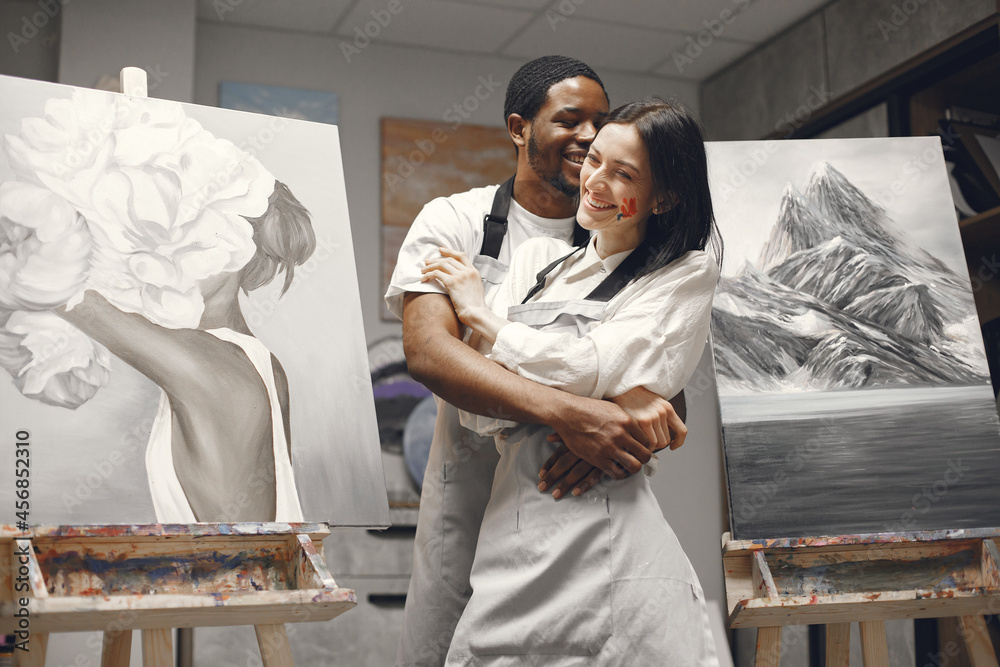 Mixed couple painting picture in workshop