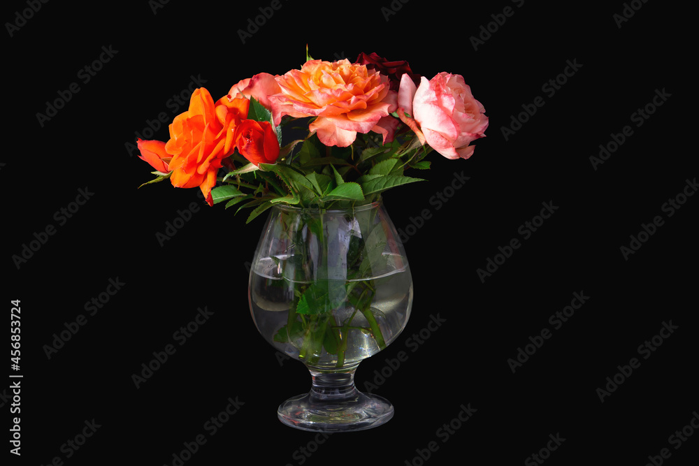 Bouquet of beautiful red roses in glass of water, on black isolated background Bouquet of beautiful red roses in glass of water, on black isolated background