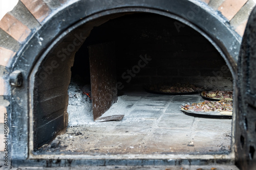 Pizza inside white painted artisan wood fired oven built outside