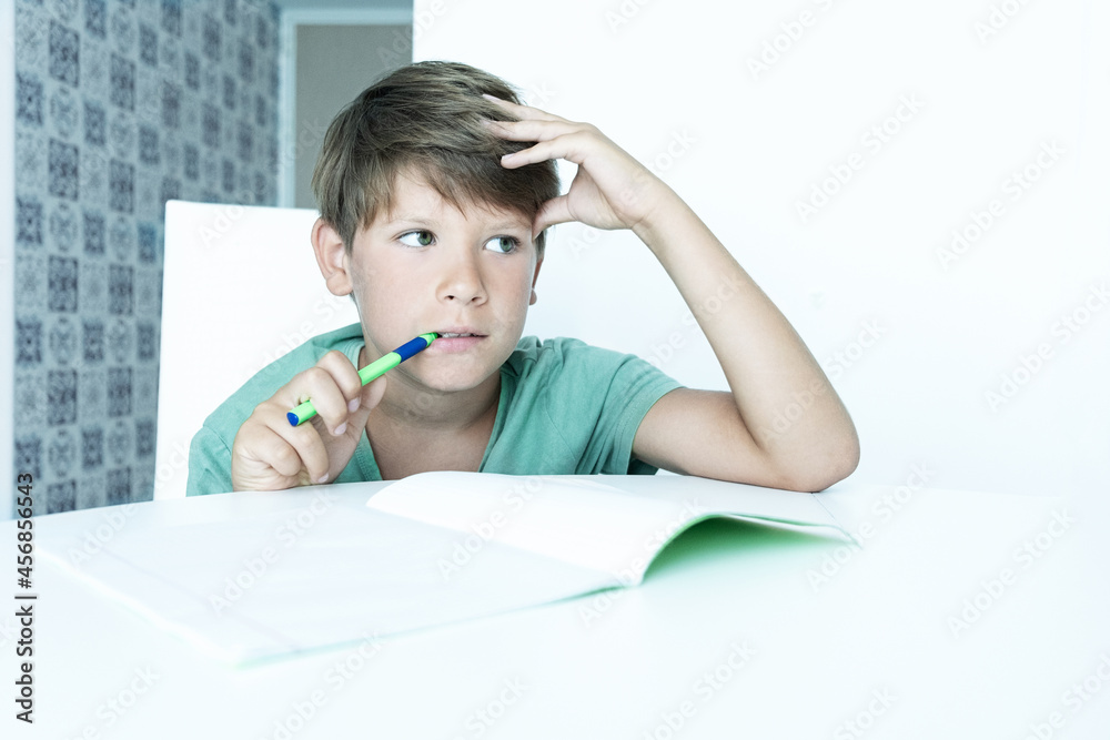 boy with book does school homework. Back to school. Unhappy schoolboy with textbooks. Distance learning boy with book does school homework. Back to school. Unhappy schoolboy with textbooks. Distance learning
