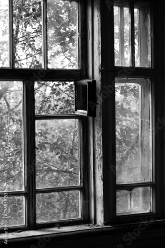 windows of an old abandoned wooden rural hospital in black and white