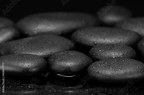 Photography black stones with drops on black background black pebbles