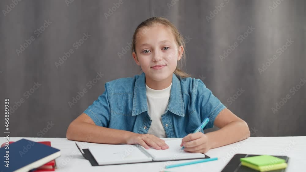Distance learning online by videocall, teen girl sitting at workplace in living room and uses a webcam to study in self-isolation at home. Distance learning online by videocall, teen girl sitting at workplace in living room and uses a webcam to study in self-isolation at home.