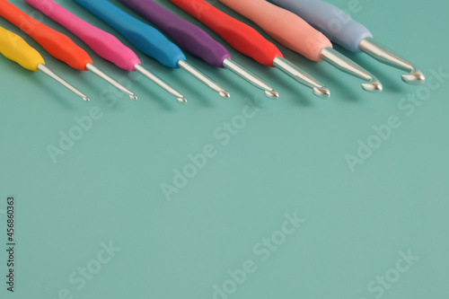 knitting multicolored crochet hooks on a blue background (ID: 456860363)