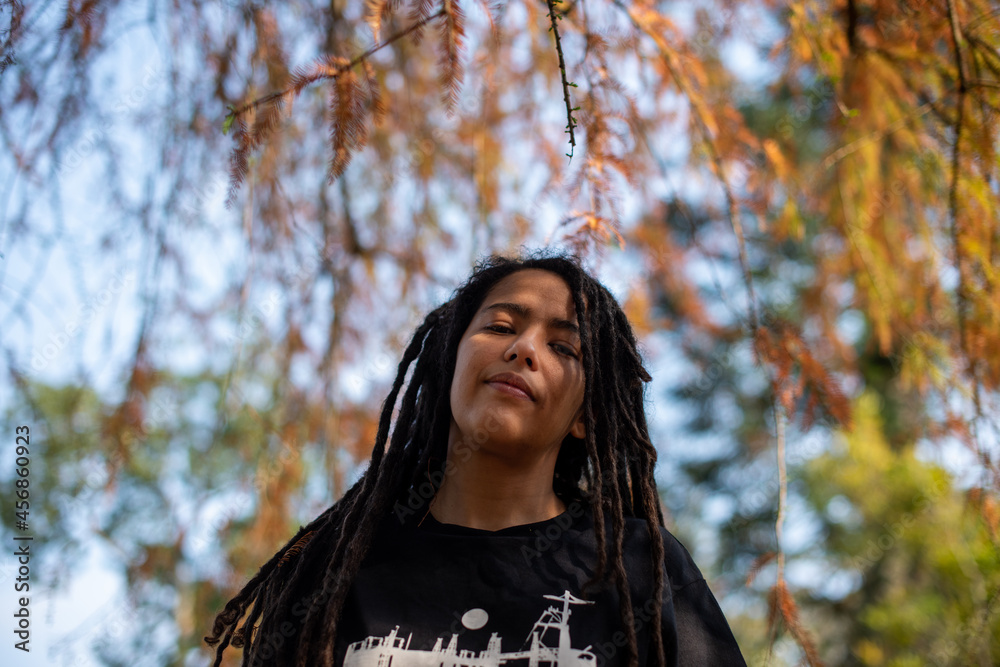Low angle view of woman with locs staring down at the camera Low angle view of woman with locs staring down at the camera