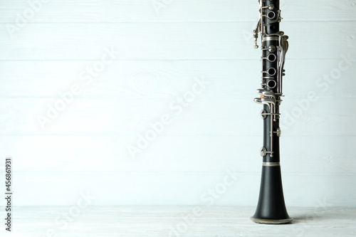 Leinwand Poster Clarinet on white wooden background, space for text