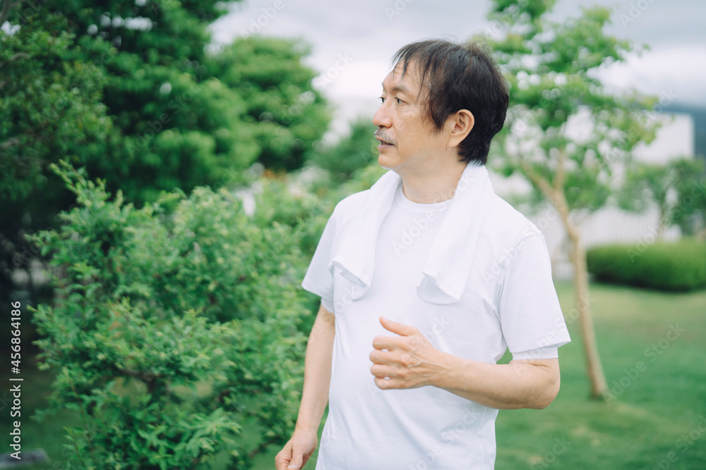 トレーニングする中高年男性(ウォーキング・真顔)
トレーニングする中高年男性(ウォーキング・真顔)