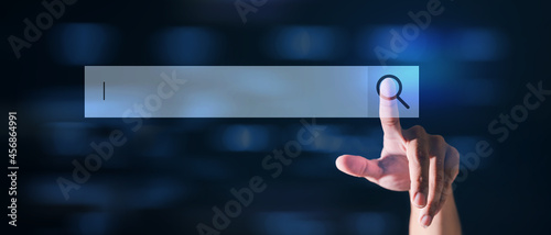 Hand touch the search button on the virtual screen to find strategy ideas internet technology information network for business with dark background.