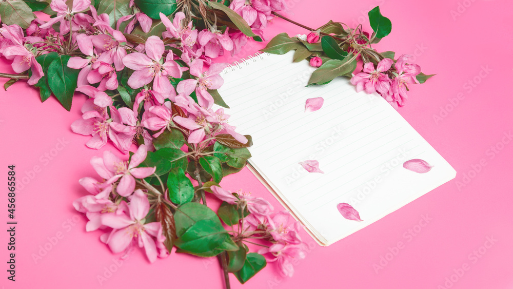Fototapeta premium flowers with blank white notepad on pink background.